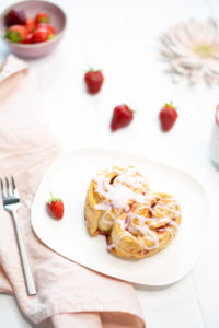 Diese Rezept für saftige Erdbeer-Schnecken mit Erdbeer-Guss sind der perfekte Sommersnack und die sommerlich, fruchtige Antwort auf klassische Zimtschnecken. #feierSun #veganbacking #veganeHefeschnecken #feierSunFood